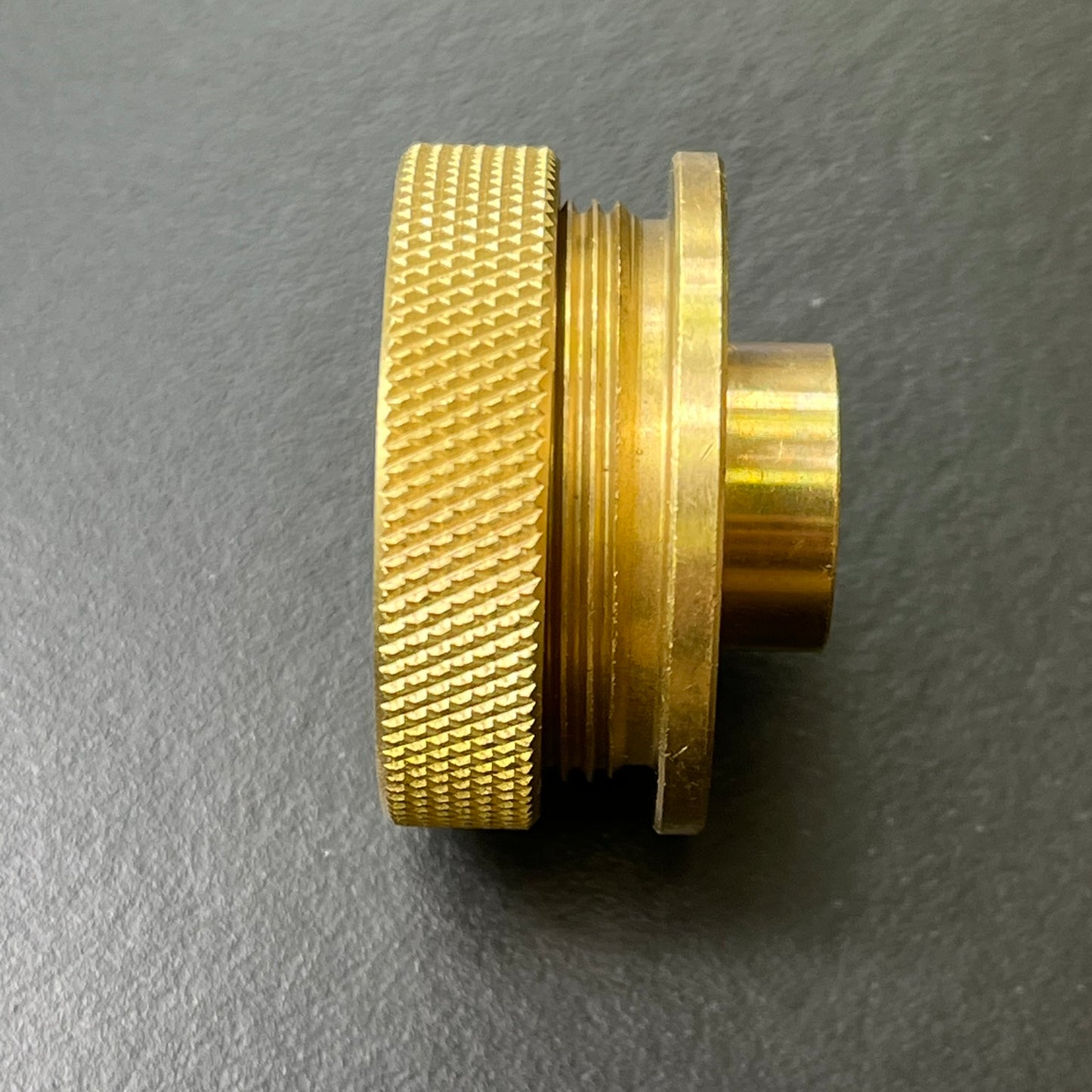 Brass guide bushing fitting on a gray background