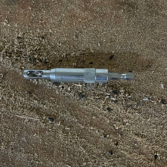 Close-up of the self-centering VIX bit with brad point drill and 1/4 inch hex shank, resting on wood shavings