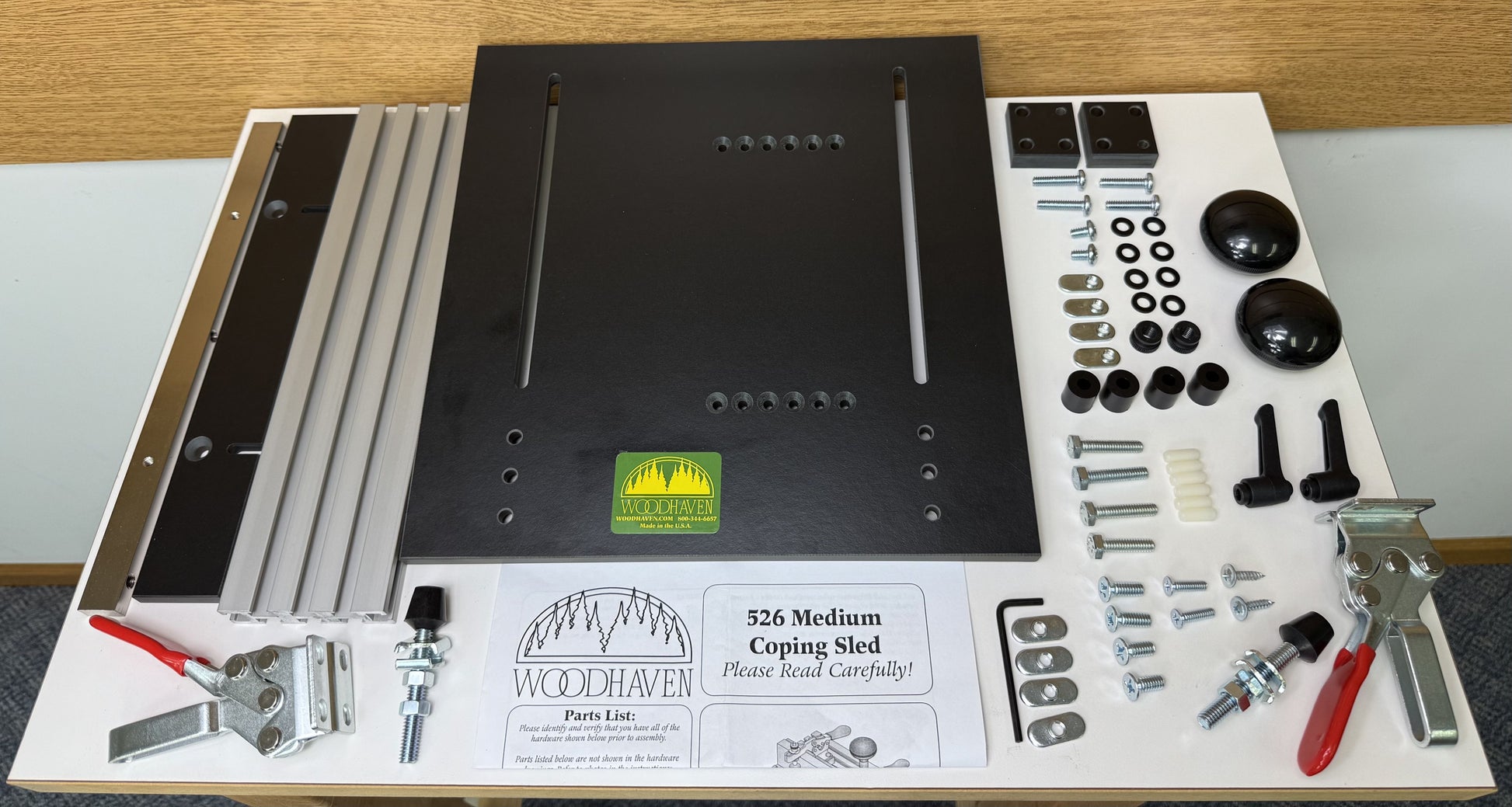 Woodworking kit with various tools and parts on a white surface