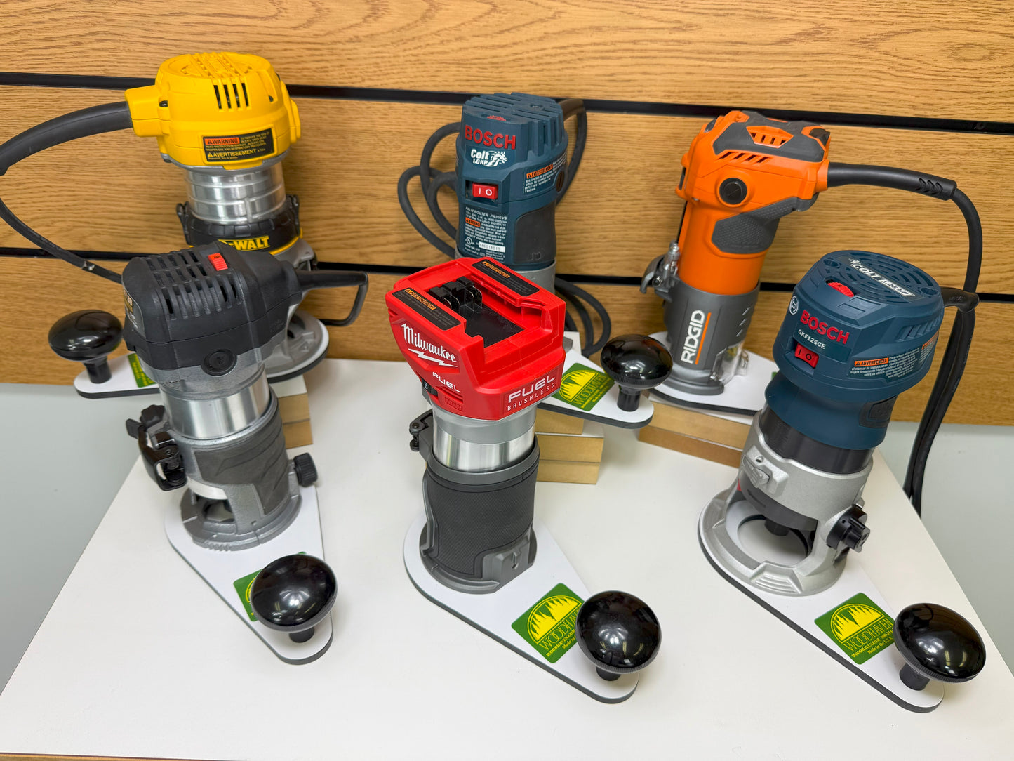 Set of various power tools on a white surface with a wooden background