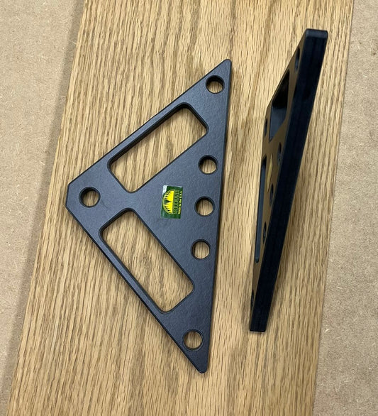 A black triangular phenolic bracket with pre-drilled mounting holes, shown from two angles on a light wood grain surface.  