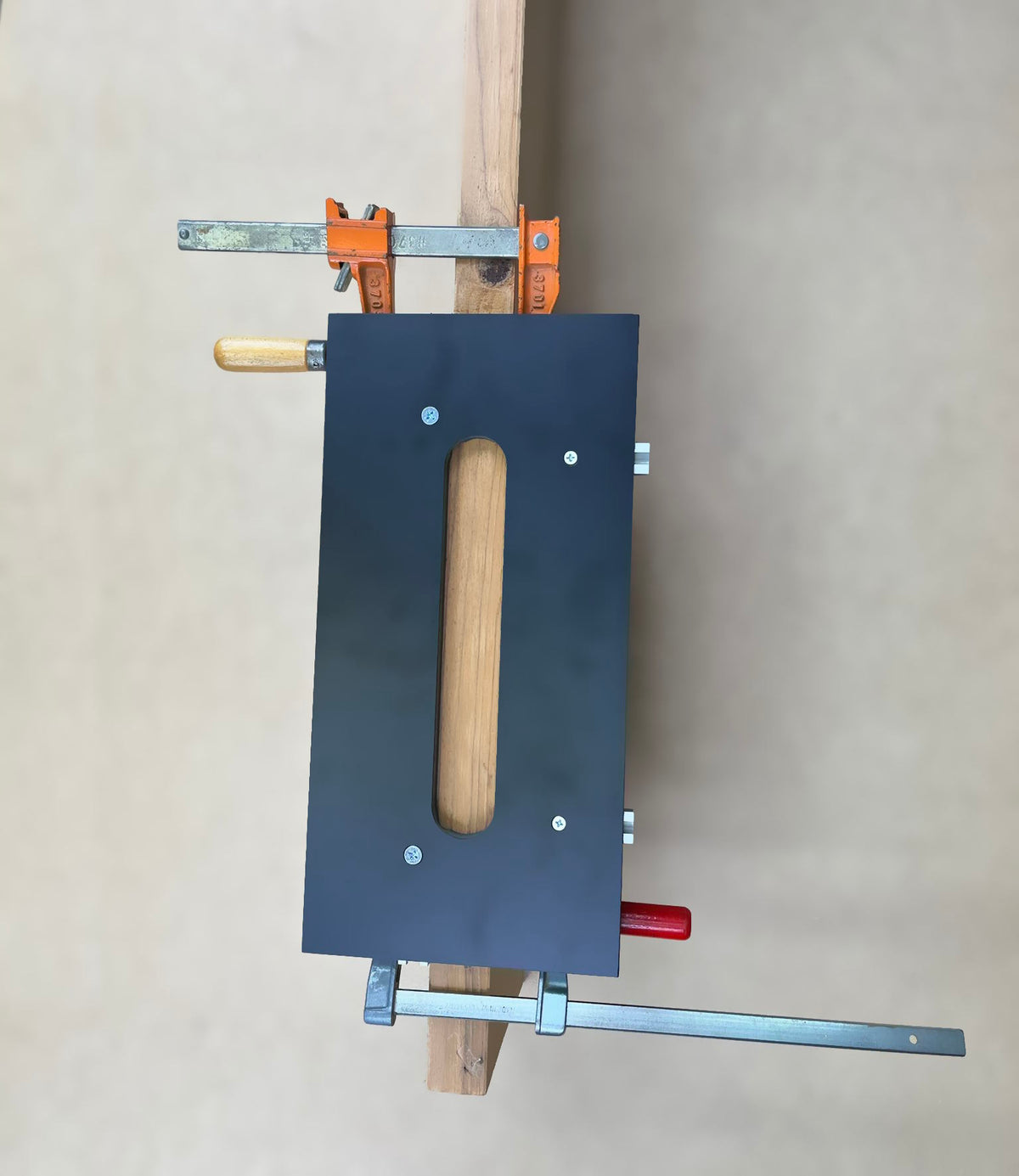 A black woodworking jig for cutting invisible hinge mortises. 
