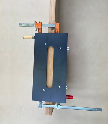 A black woodworking jig for cutting invisible hinge mortises. 